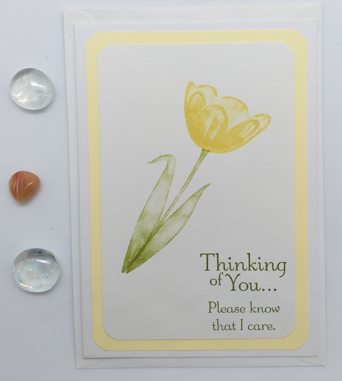 A greeting card with a yellow tulip flower illustration and the text 'Thinking of You... Please know that I care.'