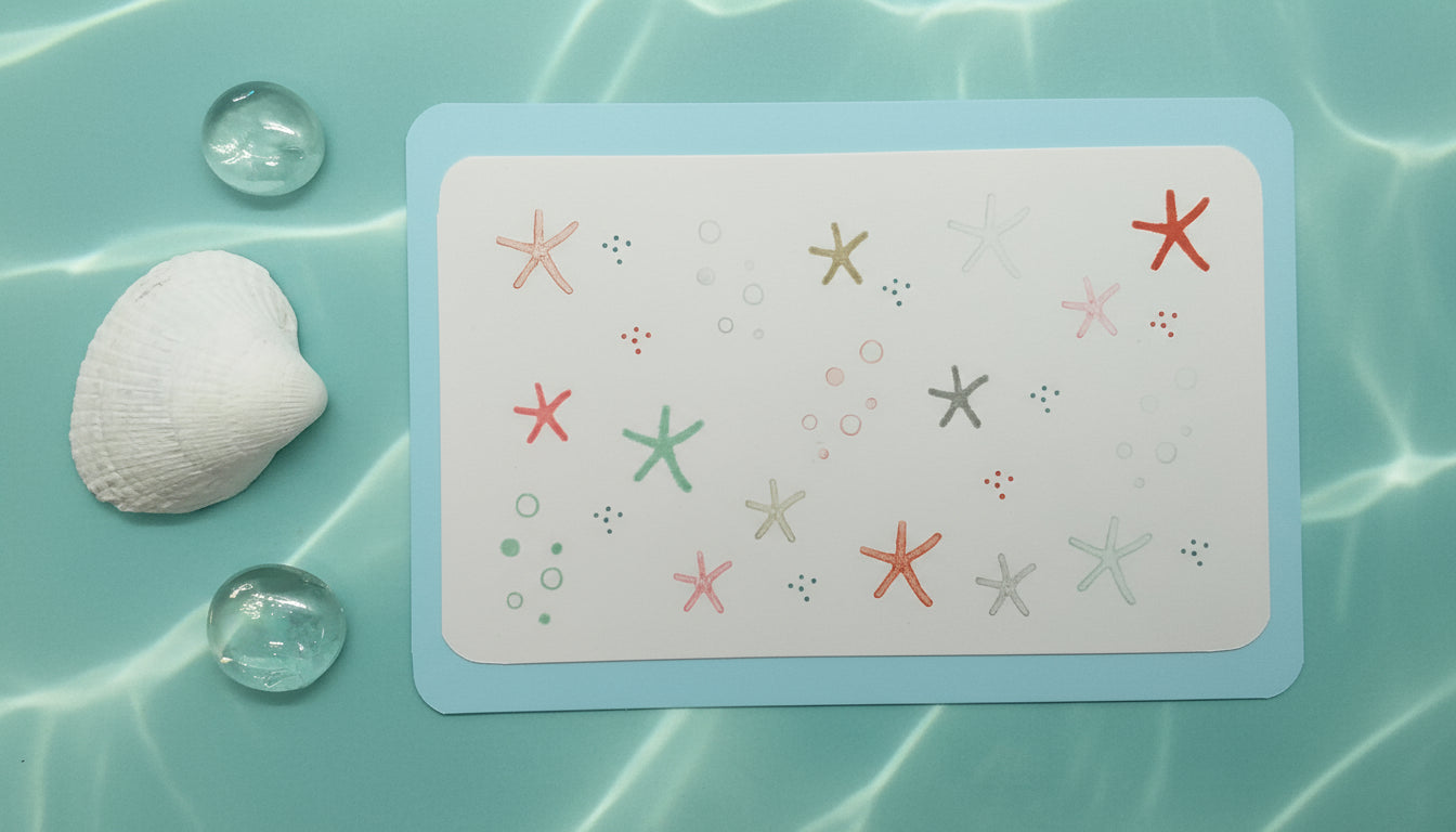 A hand-stamped greeting card with a layered design featuring multiple colored starfish, accompanied by an envelope.