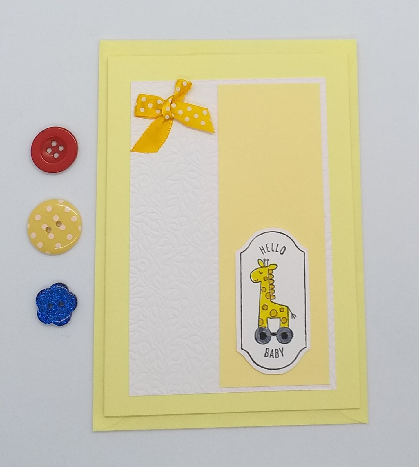 Baby shower card with a giraffe illustration on a yellow background with balloons and gifts.