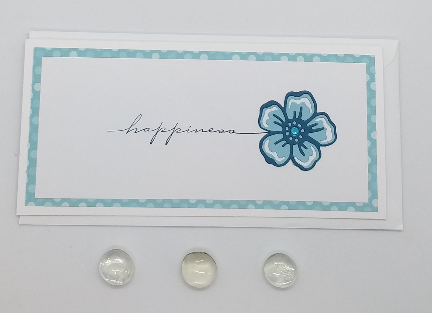 Card with blue flower and 'happiness' text on a floral background