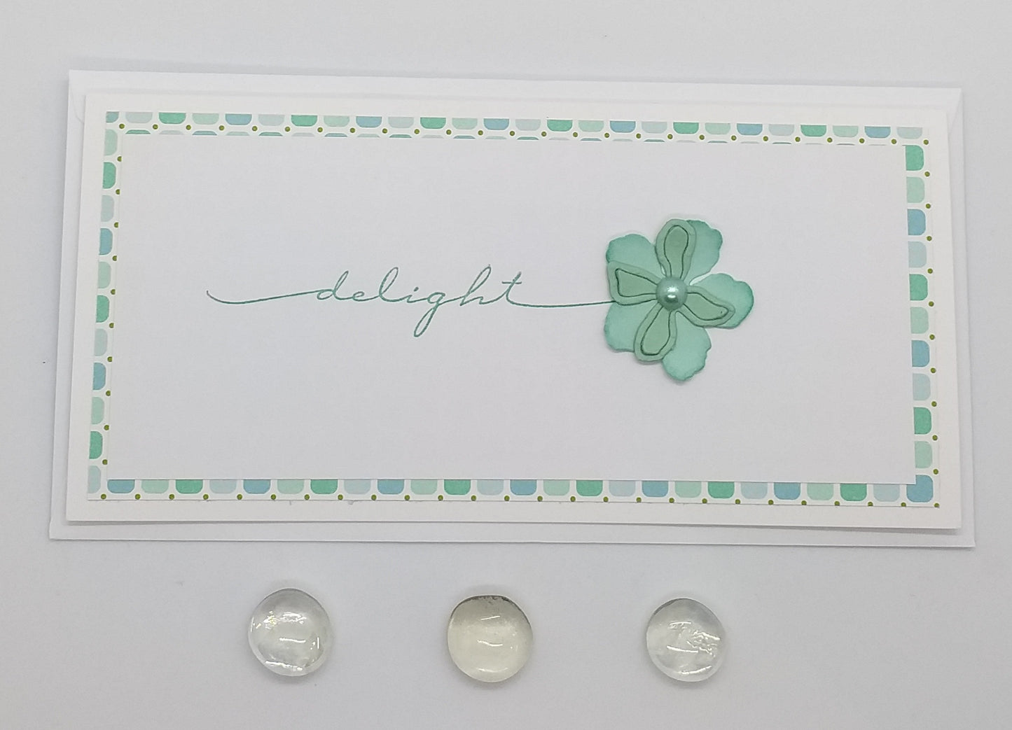 A slimline greeting card with a floral cutout design and the word 'DELIGHT' written on it, accompanied by an envelope.