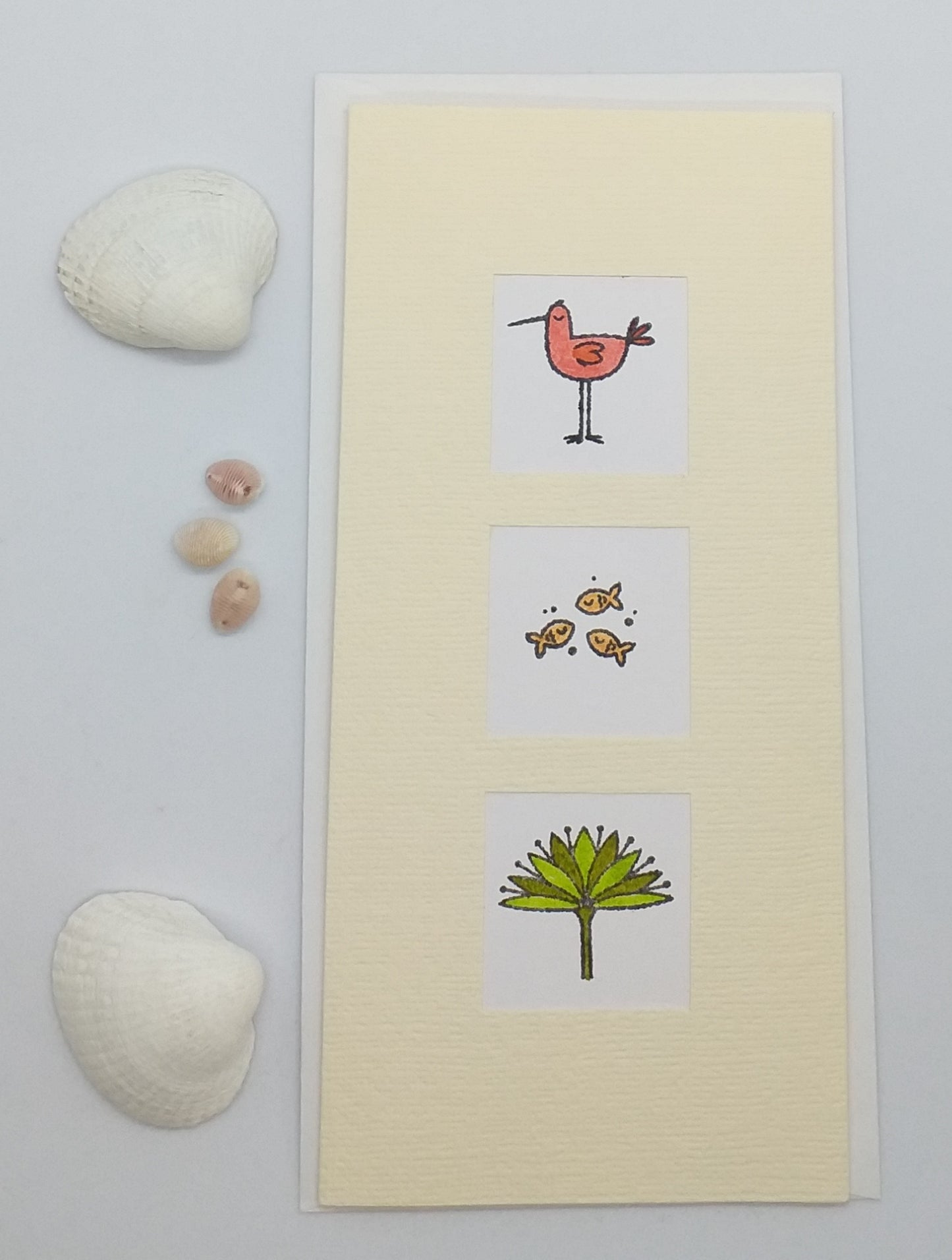 A slimline card with three windows displaying hand-stamped animal images: a bird, a fish, and a tree.