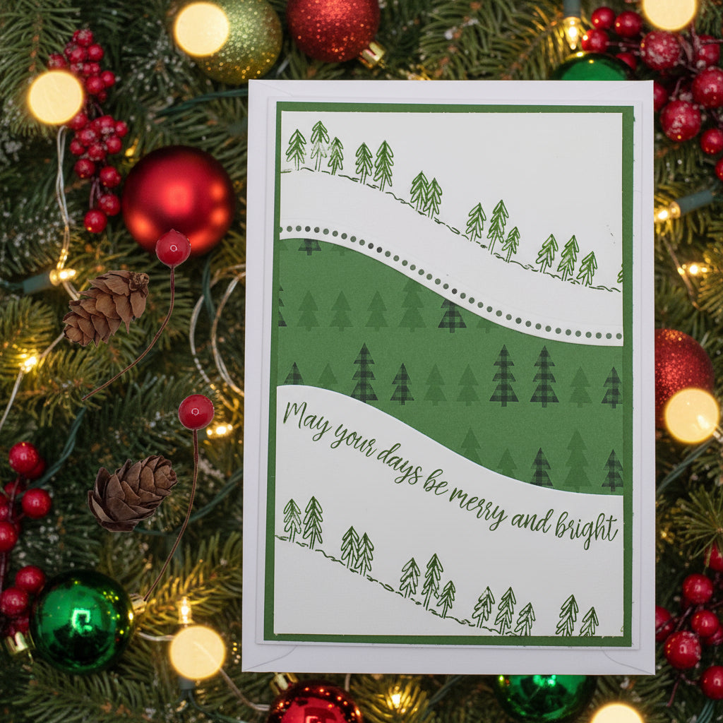 A curvy Christmas card with a green background, featuring a pathway between trees and the text 'Merry you days be merry and bright' along with some pine cones and red berries on the side.