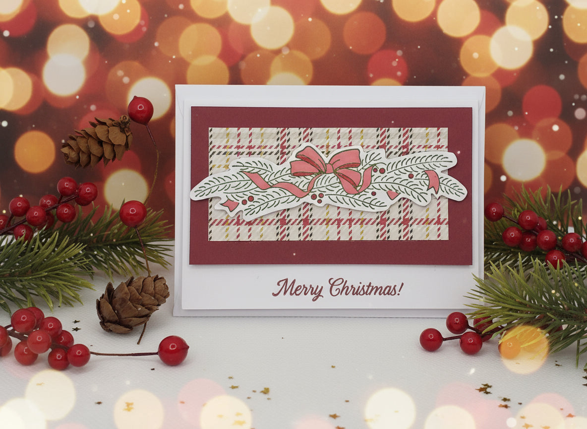 A red and white Christmas card with a tartan pattern and 'Merry Christmas' text, adorned with hand-stamped decorations.