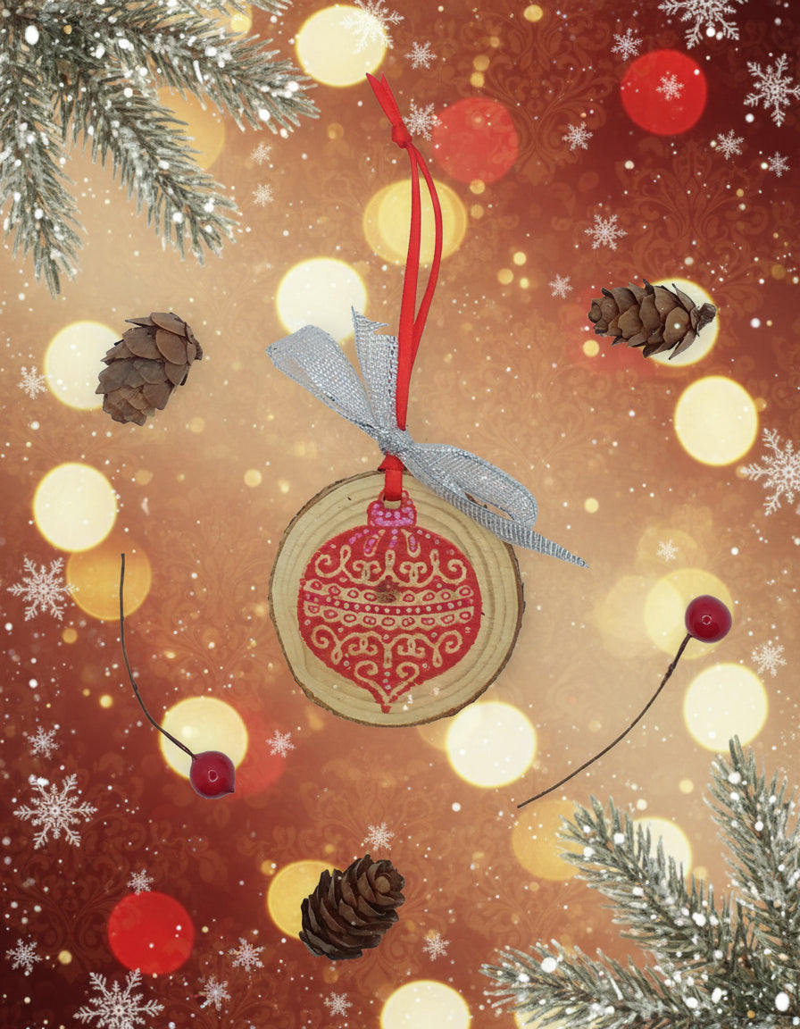 A decorative wooden slice with red bauble and hanging ribbon, accompanied by pine cones and red berries on a white background.