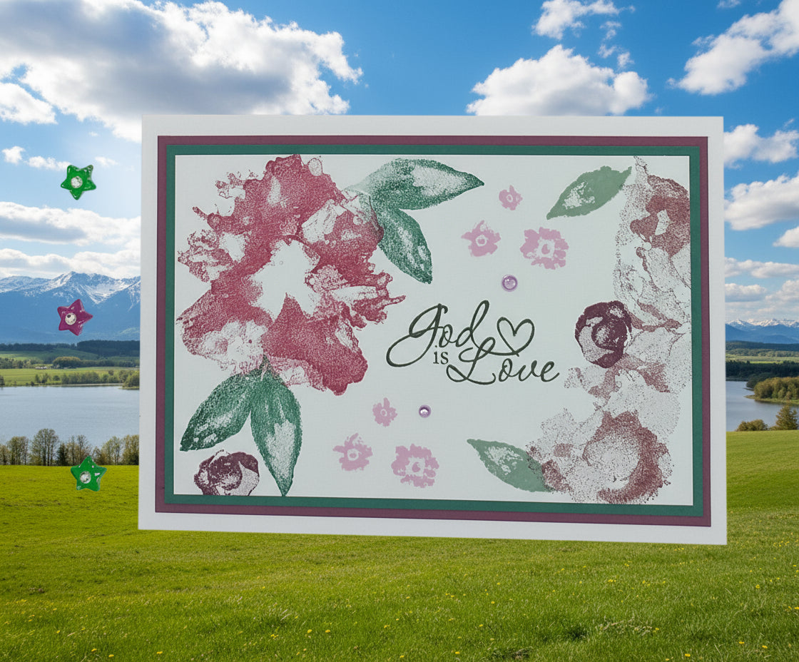 A6 card with hand-stamped design featuring a pink and green color scheme and the text 'God is Love' along with floral patterns and stars.