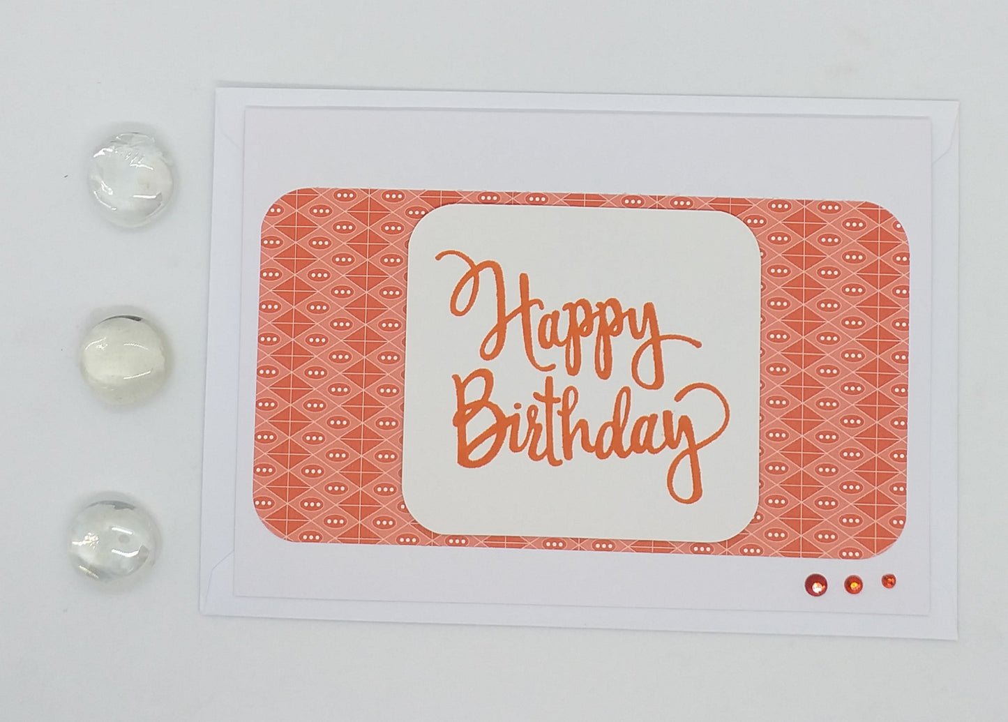 White card with 'Happy Birthday' text on a textured orange surface