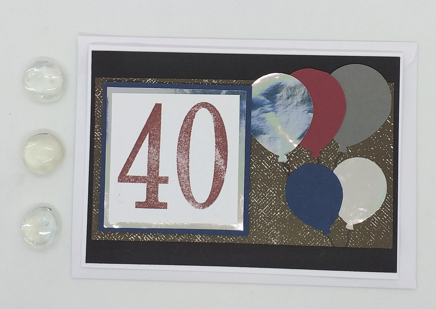 Hand stamped and layered a6 birthday card with '40' on it, featuring balloons in different colors, sent with envelope and two small round decorations.