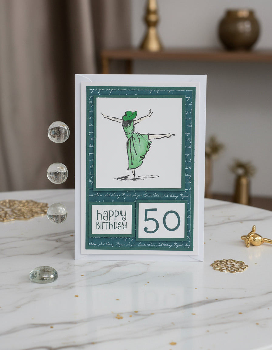 A handcrafted birthday card with a green and white color scheme, featuring a stamped image of a dancing lady, the number 50, and the text 'Happy Birthday'. The card is accompanied by two transparent embellishments.