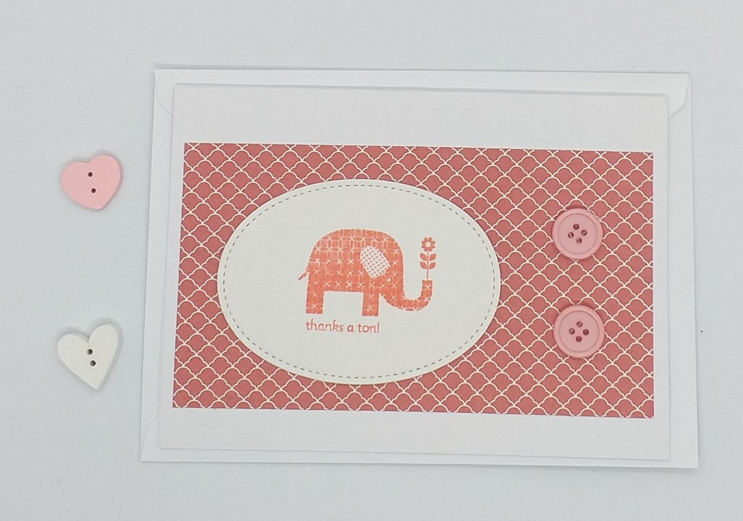 A6 size greeting card with an elephant design, adorned with buttons and accompanied by an envelope and a blank interior for a personal message.