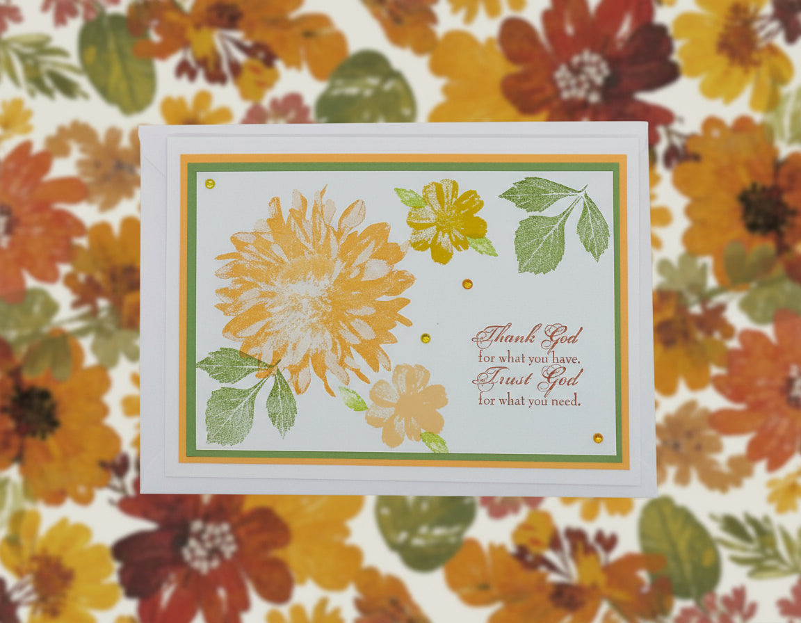 A handcrafted greeting card with a floral design and a message that reads 'Thank God for what you have, Trust God for what you need.'.