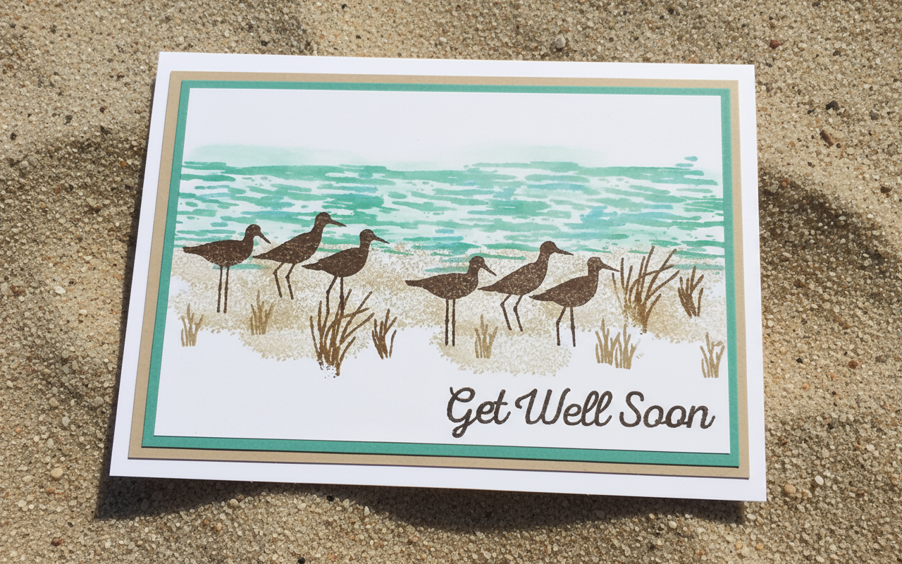 A hand-stamped and layered greeting card with a sea and bird scene, and the text 'GET WELL SOON' on the front.