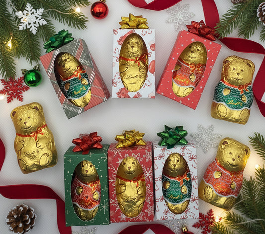 Gold teddy bears in colorful boxes on a white background