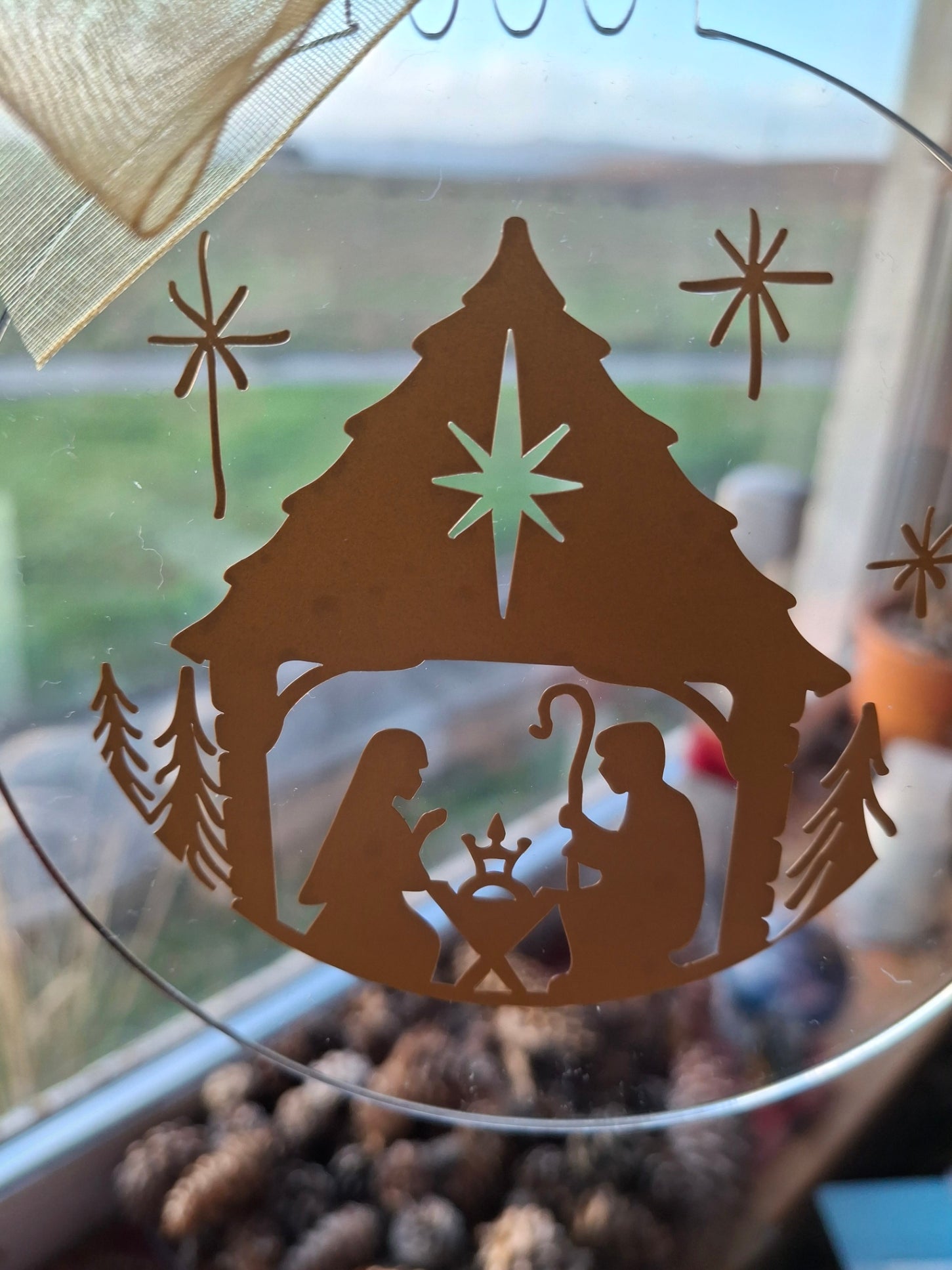 Decorative glass with cut-out design of a fish and starfish on a blurred natural background