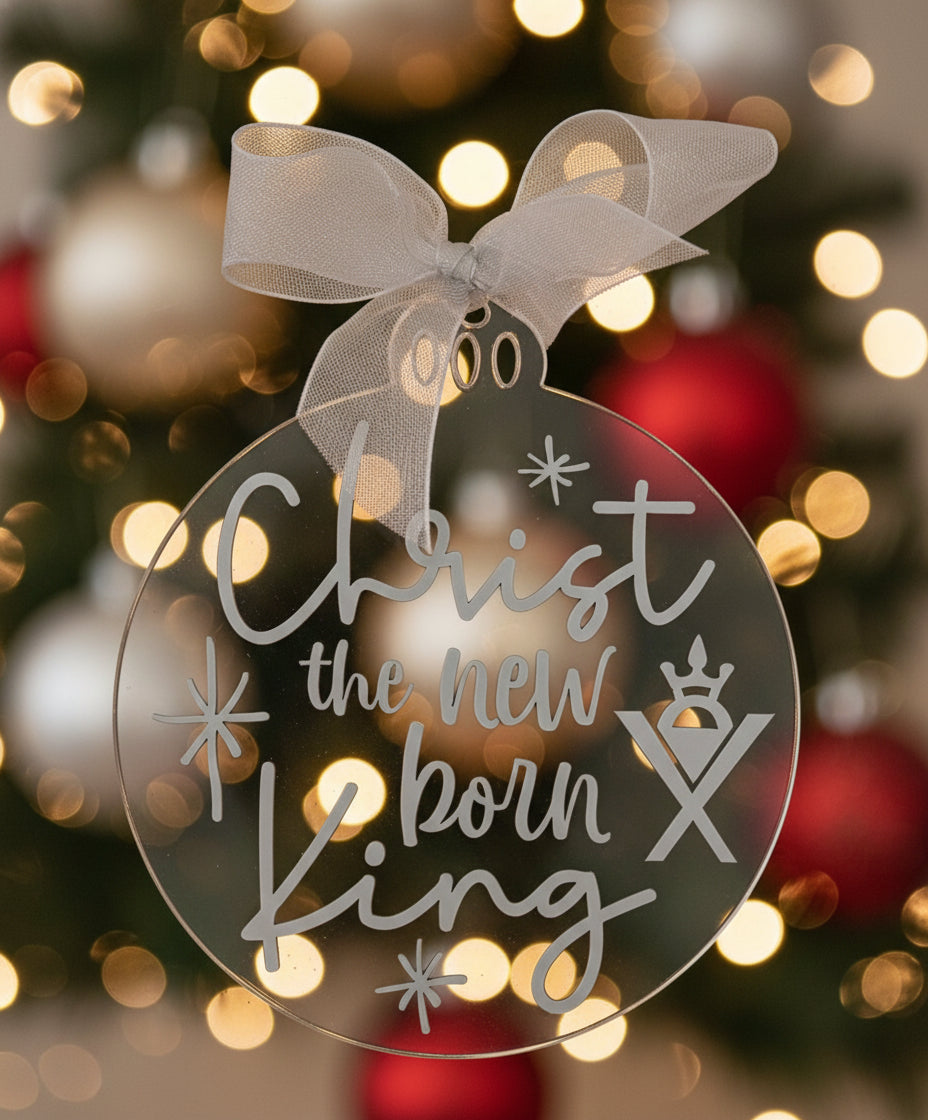 Decorative round ornament with 'Christ the new born King' text and a bow on a light gray background