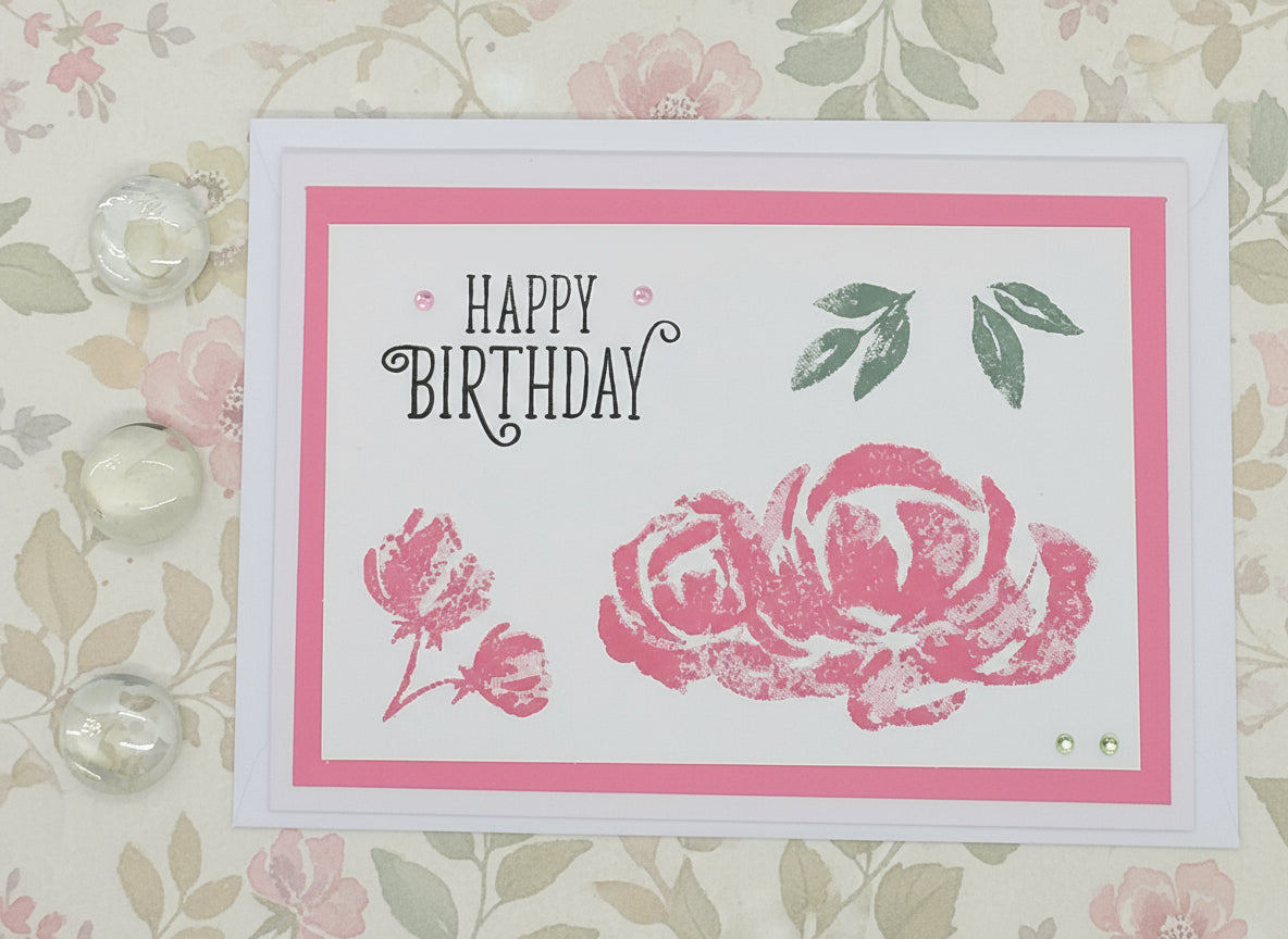 Birthday card with pink roses and 'Happy Birthday' text on a floral background