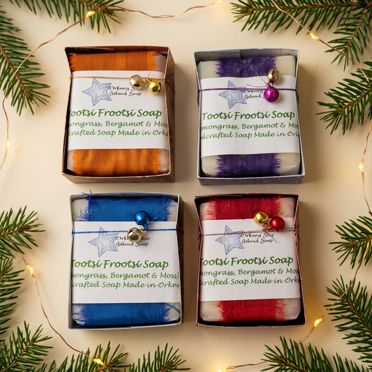 Four Tootsi Frootsi boxed soaps with colourful bands and decorative bells in a festive setting