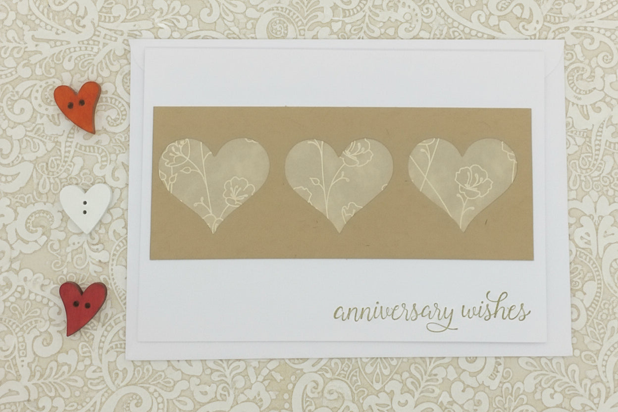 Card with heart designs and 'anniversary wishes' text on a decorative background