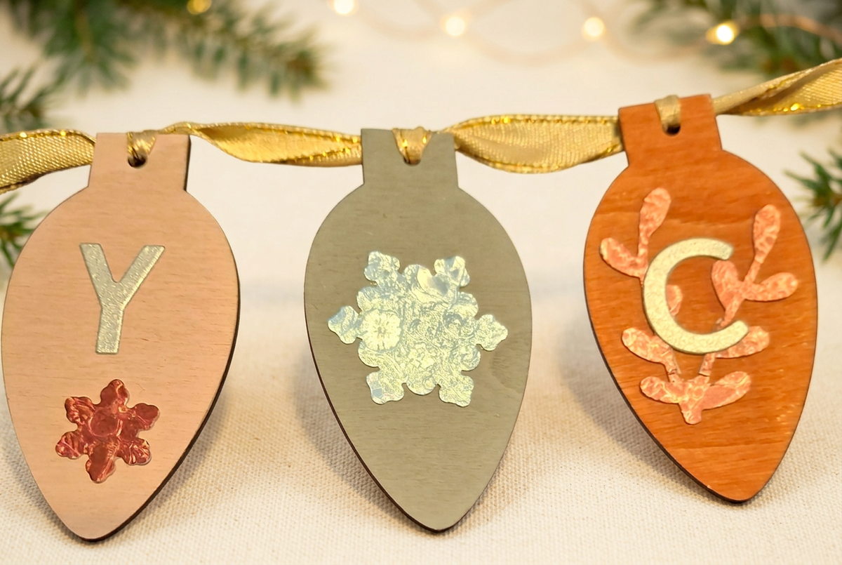 Three wooden bulb decorations with festive background